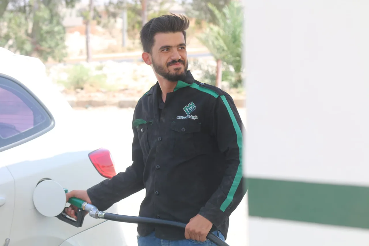 عامل في محطة يارا في درعا يبتسم أثناء التعبئة